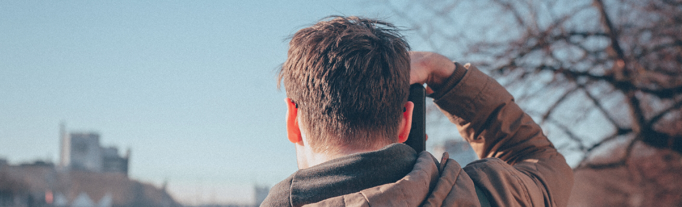 man holding camera looking into distance