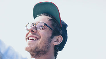 Young man smiling wearing a cap