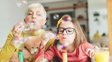 Older lady and young girl blowing bubbles