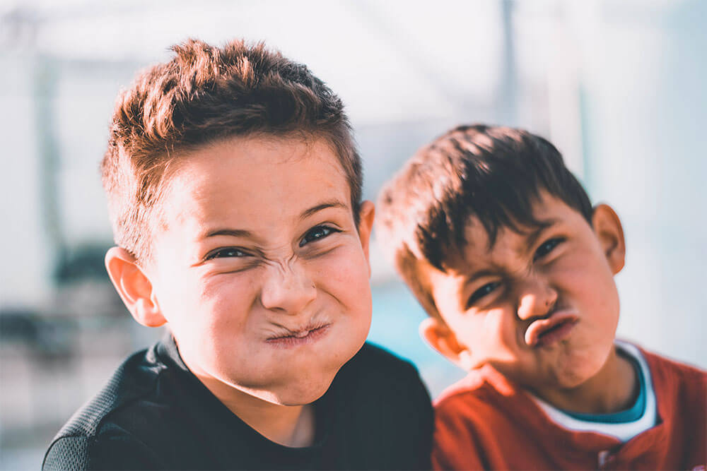 Two Young Boys Pulling Silly Faces at the Camera