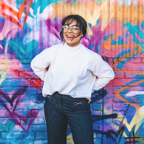 Woman standing against graffiti wall