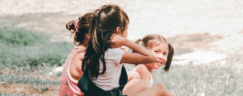 children sitting together in park