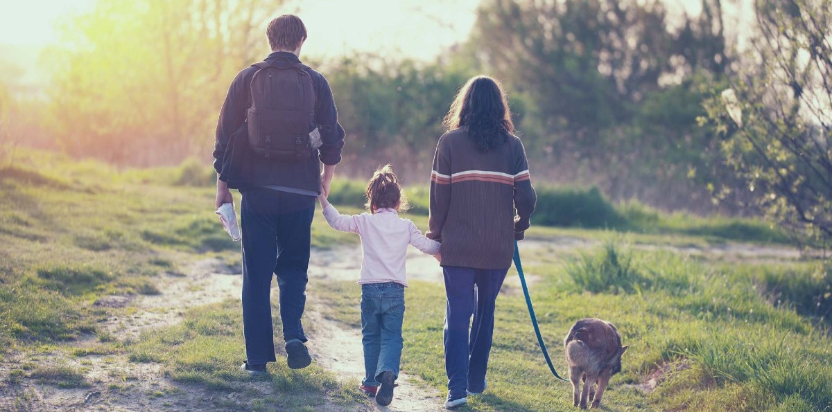 young family walking with dog