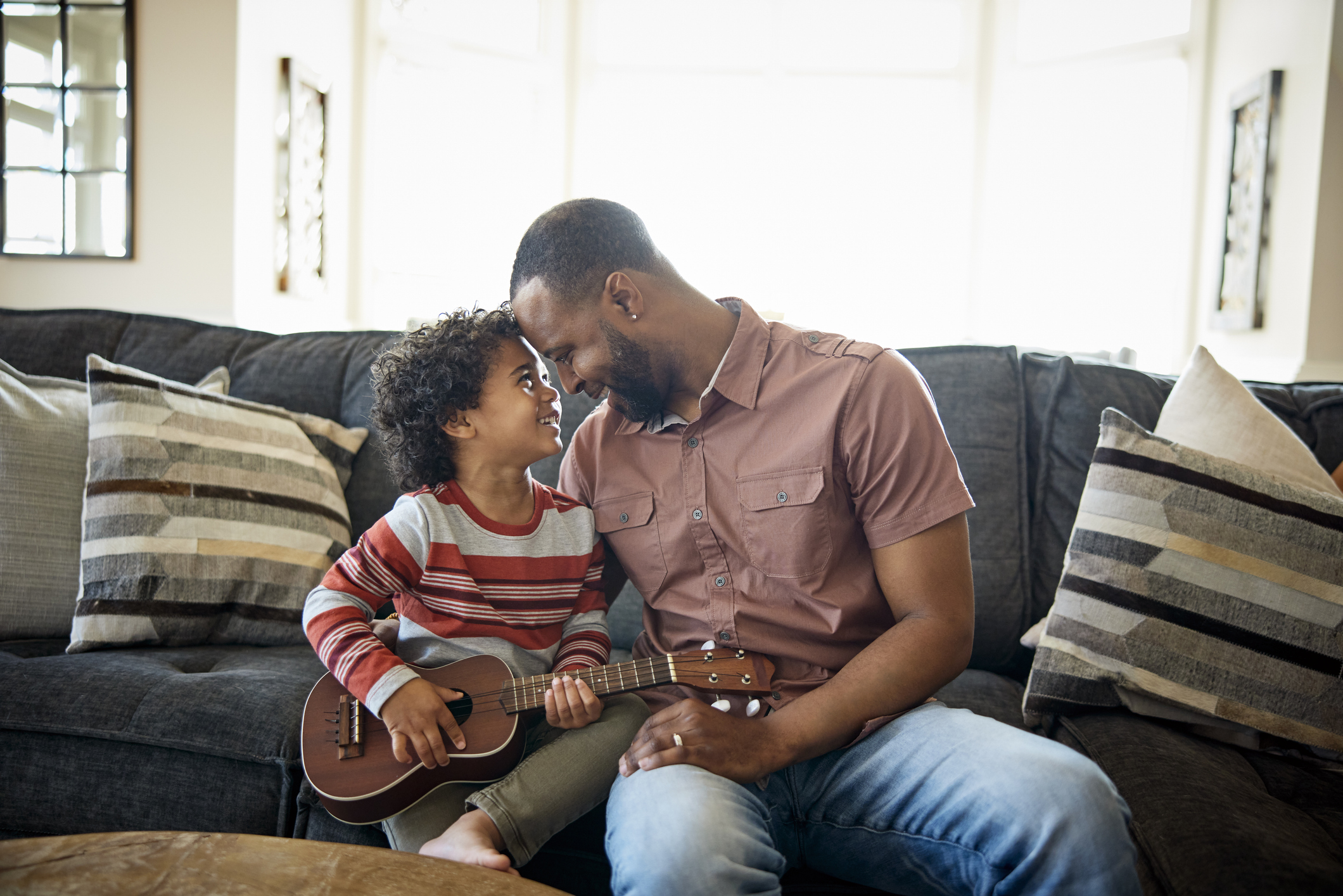 Father and son sitting on sofa with a guitar.jpg