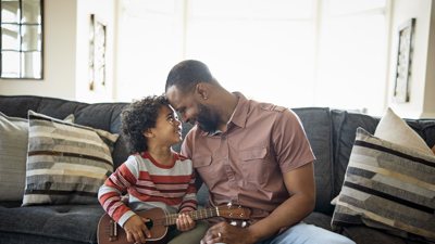 Father and son sitting on sofa with a guitar.jpg