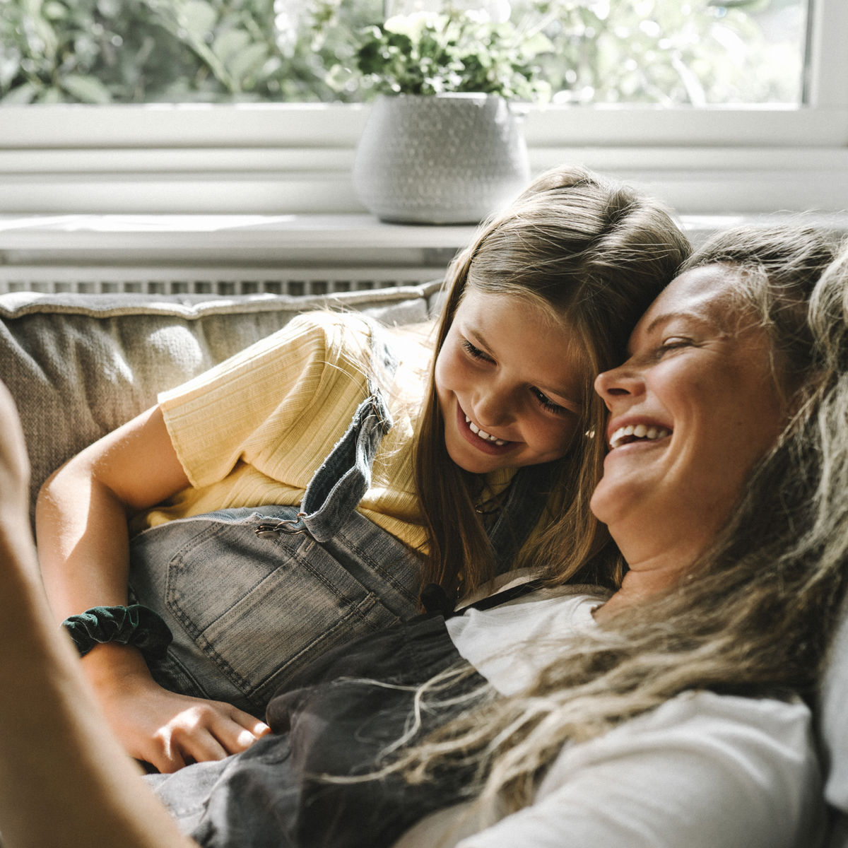 A mother and daughter on the sofa looking at a phone.jpg