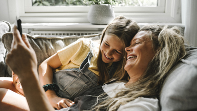 A mother and daughter on the sofa looking at a phone.jpg