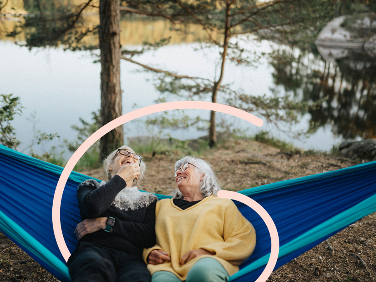 Two women sitting in a hammock in scenic location