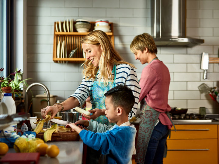 Two adults preparing food in the kitchen with a child.jpg