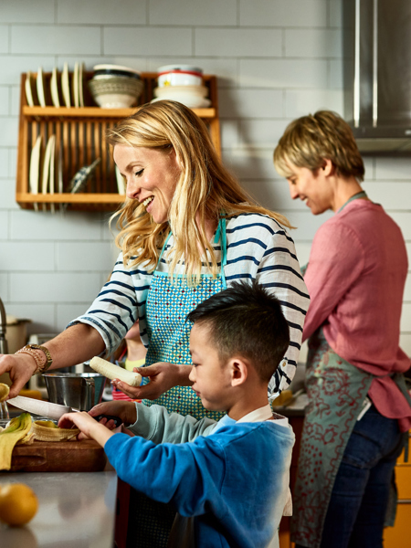 Two adults preparing food in the kitchen with a child.jpg