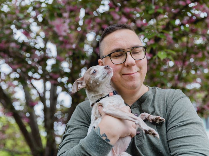 Person outside holding small dog