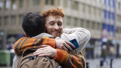Two friends hugging in a city.jpg