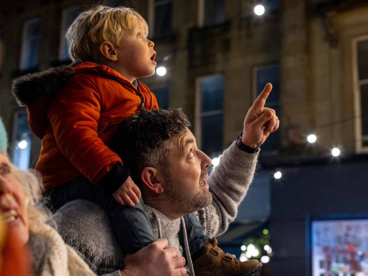 Man with child on his shoulders pointing at something.jpg