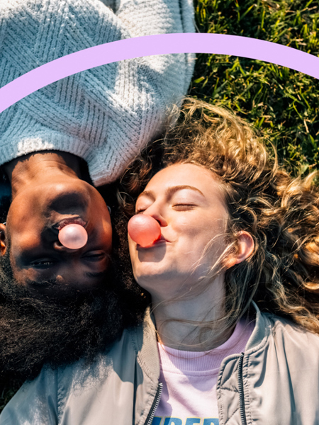 Two young women lying down on grass with bubblegum.jpg