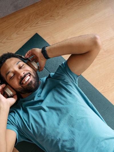 Man lying on exercise mat wearing headphones.jpg